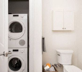 A full-size Bosch washer and dryer unit is discreetly located in the bathroom storage closet